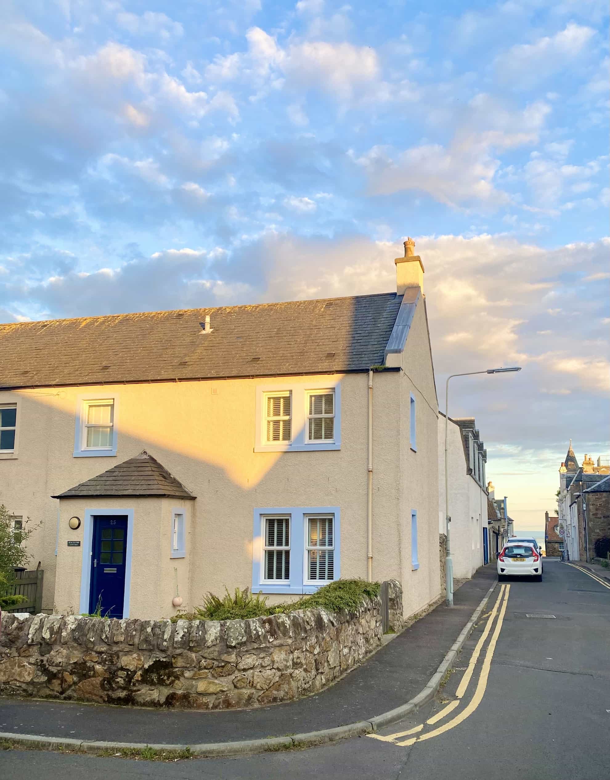 A house with a blue door on the corner of a street