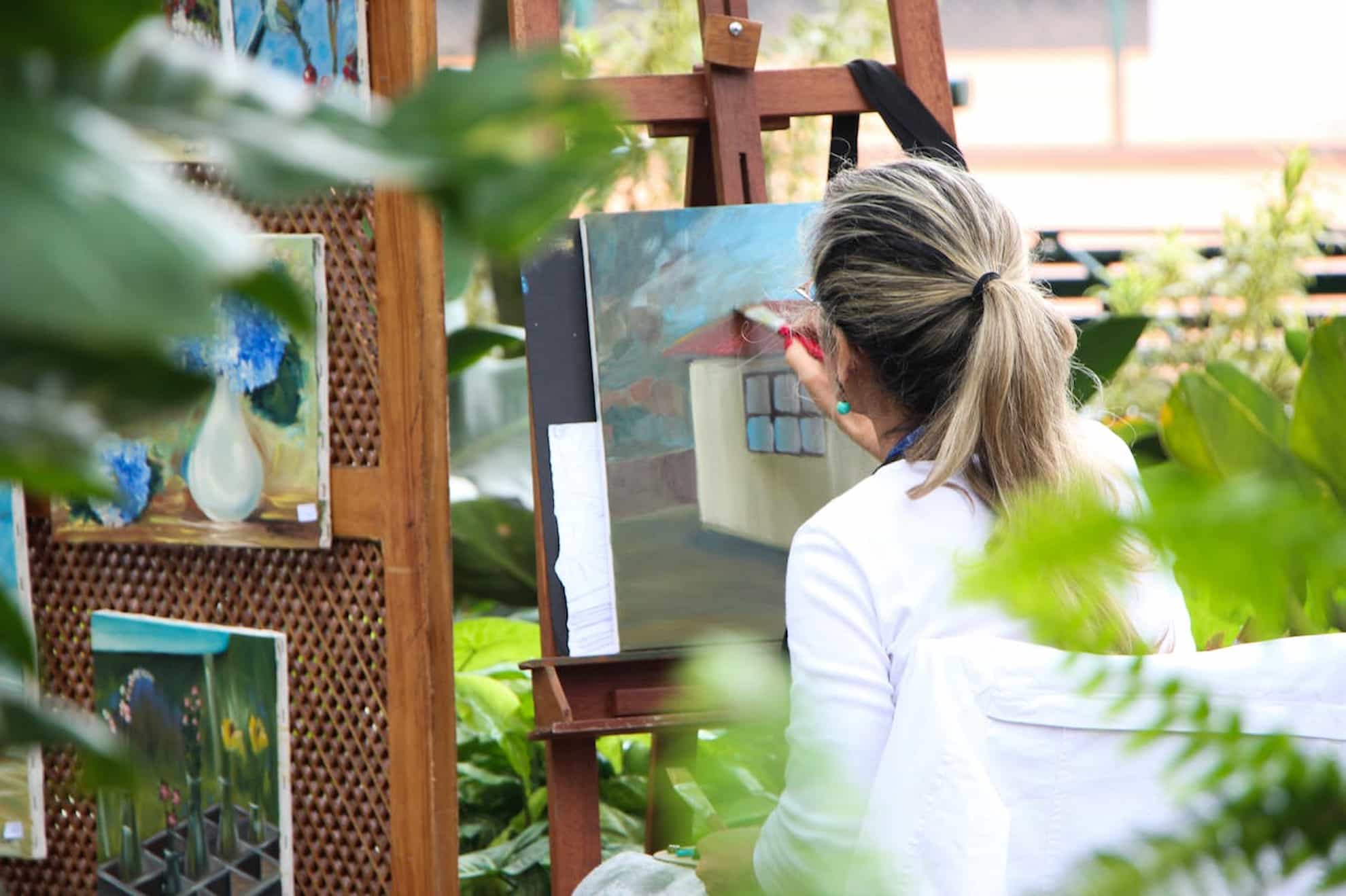 A woman painting outside in a garden