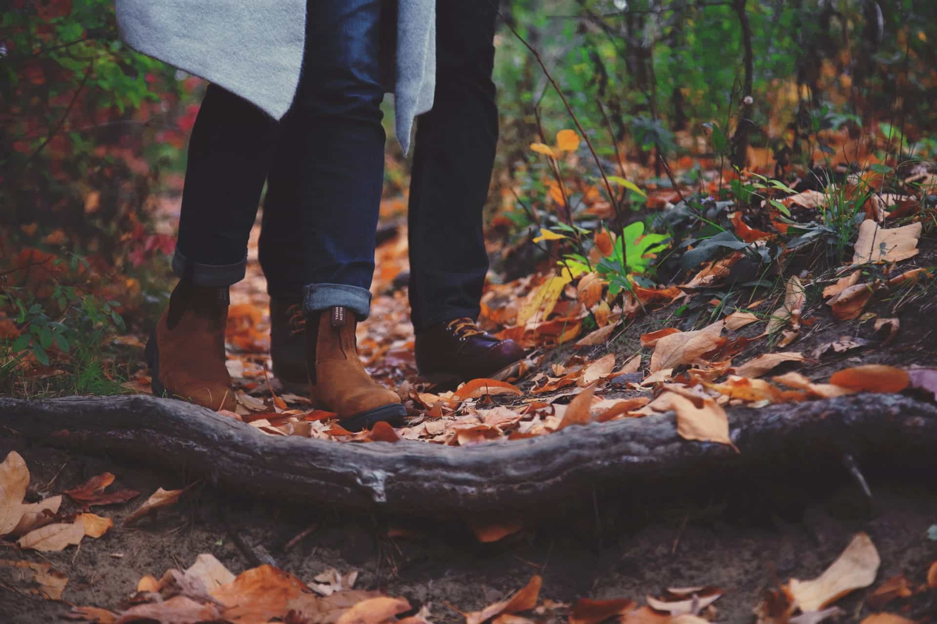 A man and a woman walking through a forest